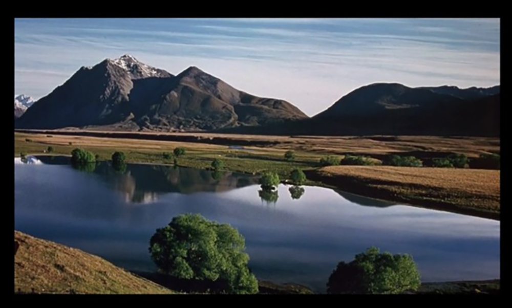 A lake surrounded by mountains  Description automatically generated