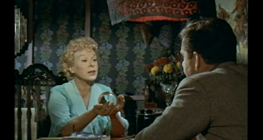 Nellie (Brenda de Banzie) consulting her crystal ball.