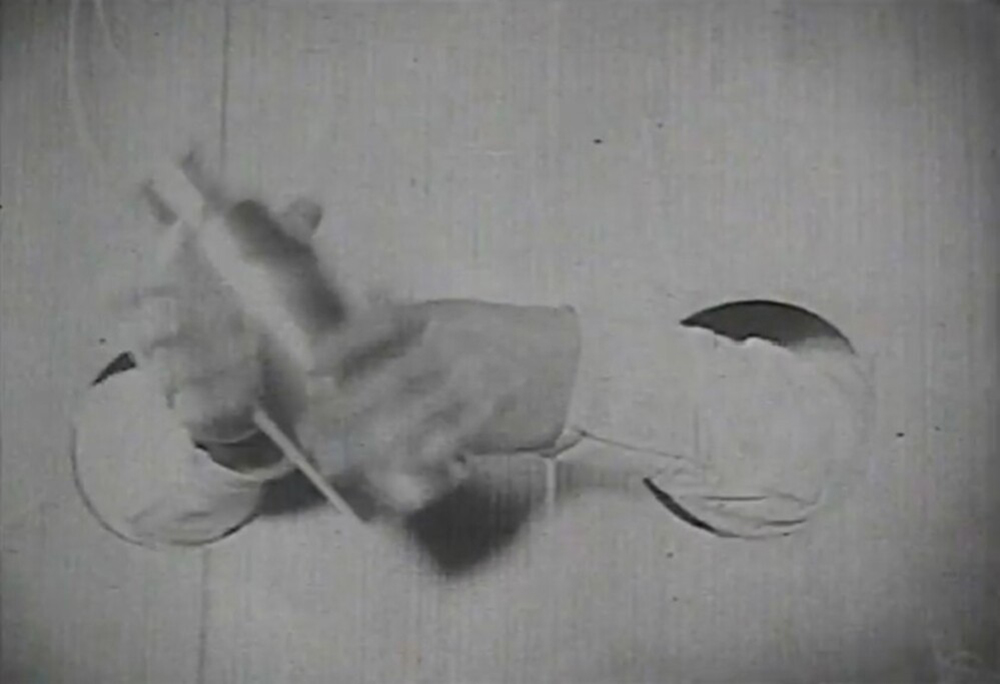 Two hands shaking a cocktail shaker in a surreal sequence from An Andalusian Dog.
